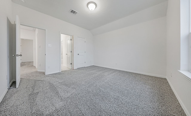 unfurnished bedroom with a closet, lofted ceiling, and carpet floors