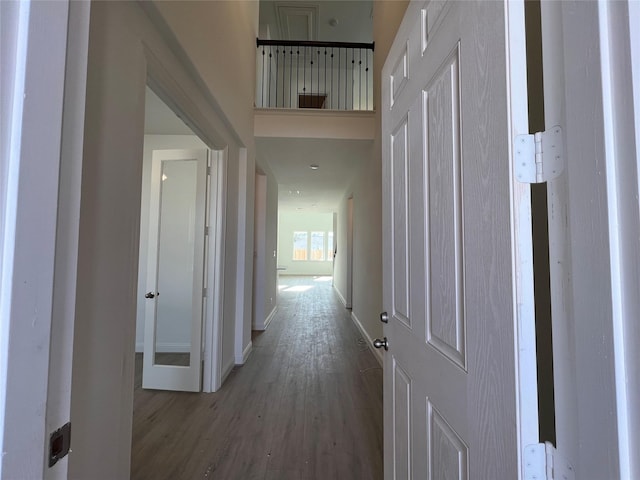 hallway with hardwood / wood-style flooring and a high ceiling