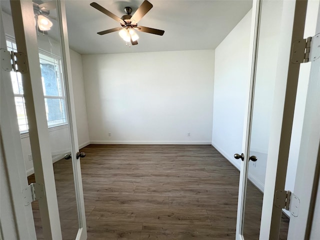 empty room featuring dark wood-type flooring and ceiling fan