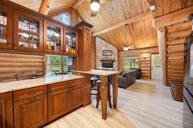 interior space featuring plenty of natural light, ceiling fan, wooden ceiling, and a fireplace