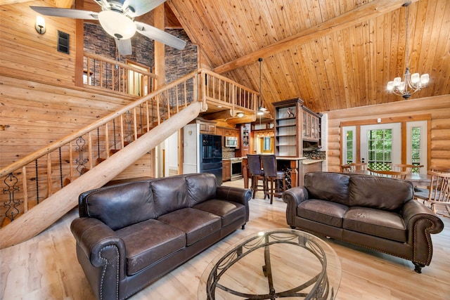 living room with ceiling fan with notable chandelier, high vaulted ceiling, and light hardwood / wood-style flooring