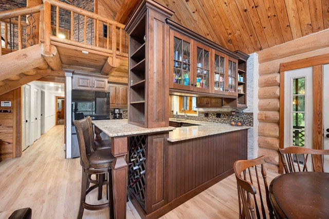 kitchen featuring kitchen peninsula, light stone countertops, wooden ceiling, light hardwood / wood-style floors, and lofted ceiling