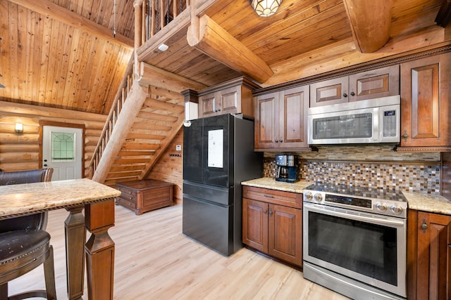 kitchen with light stone countertops, appliances with stainless steel finishes, rustic walls, wood ceiling, and light hardwood / wood-style flooring