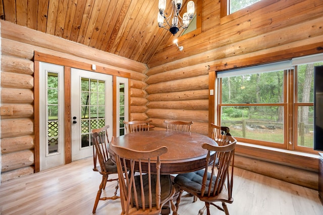 dining area with a healthy amount of sunlight, vaulted ceiling, and light hardwood / wood-style floors