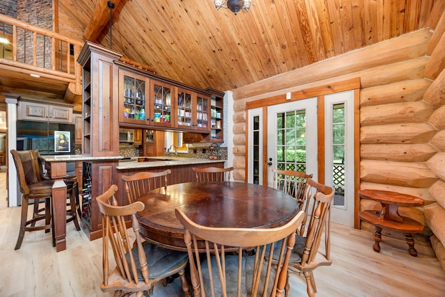 dining space featuring log walls, high vaulted ceiling, wood ceiling, and light wood-type flooring