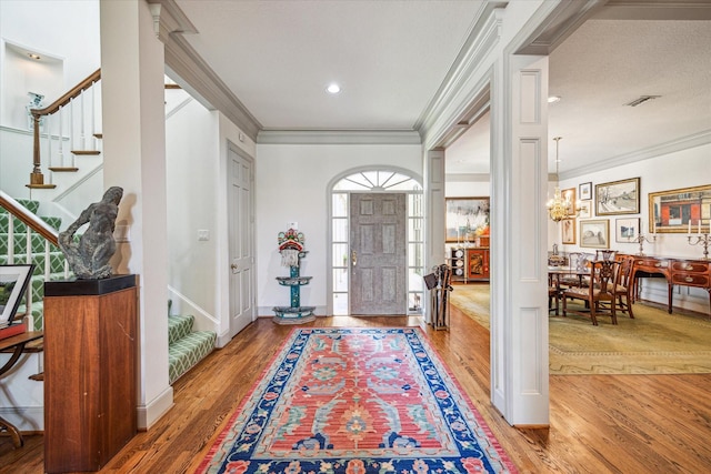 2509 Westgate Dr, Houston, TX 77019 - entryway featuring stairs, ornamental molding, wood finished floors, and a chandelier