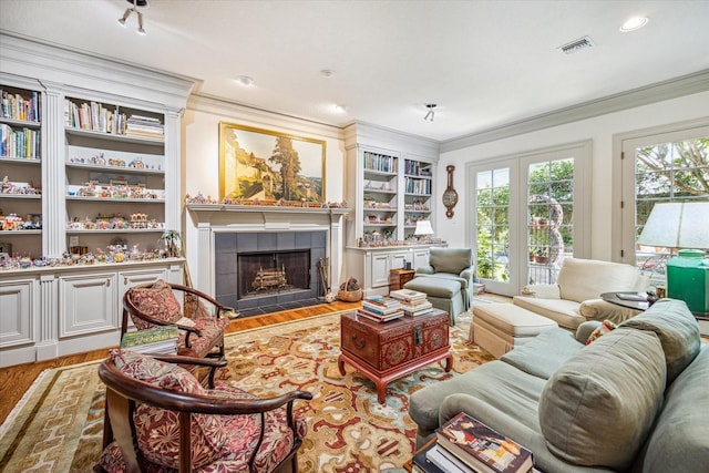 2509 Westgate Dr, Houston, TX 77019 - living area with crown molding, built in shelves, wood finished floors, and a fireplace