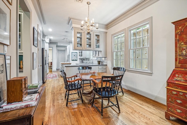 2509 Westgate Dr, Houston, TX 77019 - dining area featuring light wood-type flooring, crown molding, a chandelier, and a ceiling fan