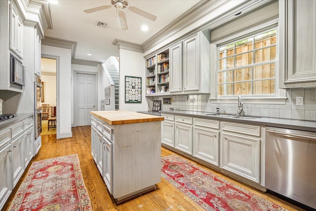 2509 Westgate Dr, Houston, TX 77019 - kitchen with appliances with stainless steel finishes, butcher block counters, crown molding, ceiling fan, and open shelves