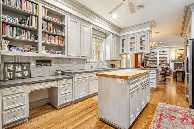 2509 Westgate Dr, Houston, TX 77019 - kitchen with butcher block counters, ornamental molding, ceiling fan, built in study area, and open shelves