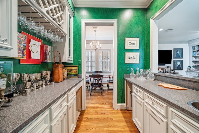 2509 Westgate Dr, Houston, TX 77019 - kitchen with ornamental molding, light wood-type flooring, white cabinetry, and a chandelier