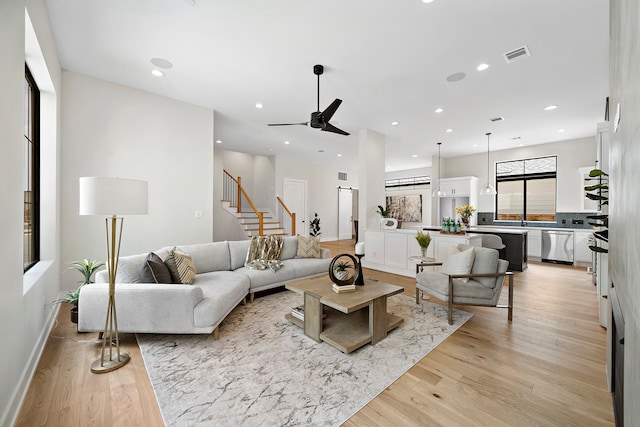 living room with light wood-type flooring and ceiling fan