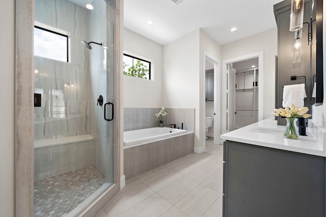 full bathroom with vanity, toilet, plus walk in shower, and tile patterned flooring