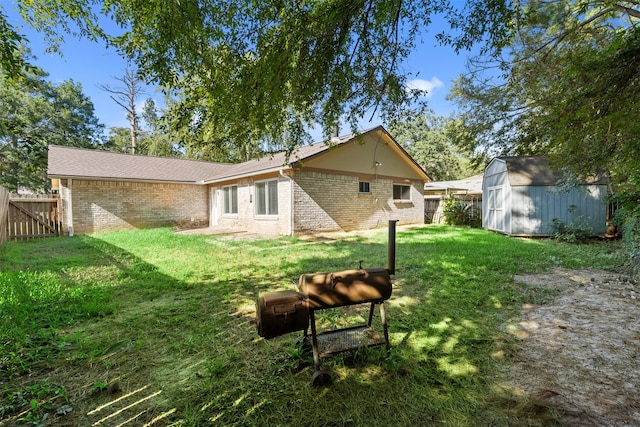 back of property featuring a storage shed and a yard