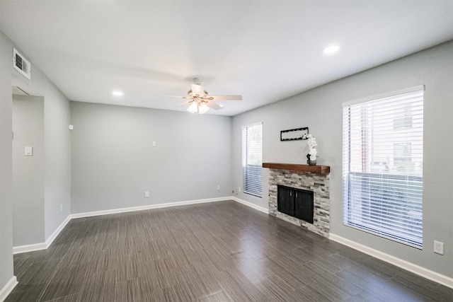 unfurnished living room with ceiling fan, a fireplace, and dark hardwood / wood-style floors