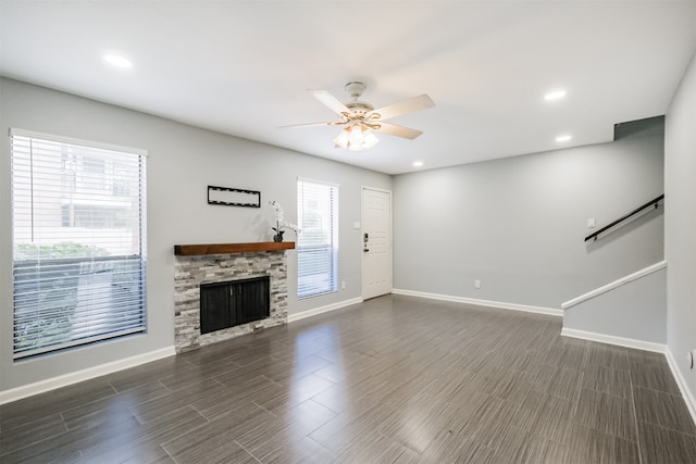 unfurnished living room featuring ceiling fan, a fireplace, and a wealth of natural light