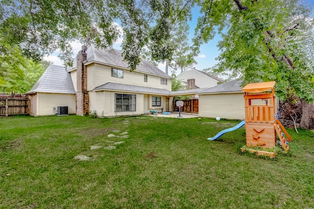 rear view of house featuring a lawn, a patio, and central AC unit