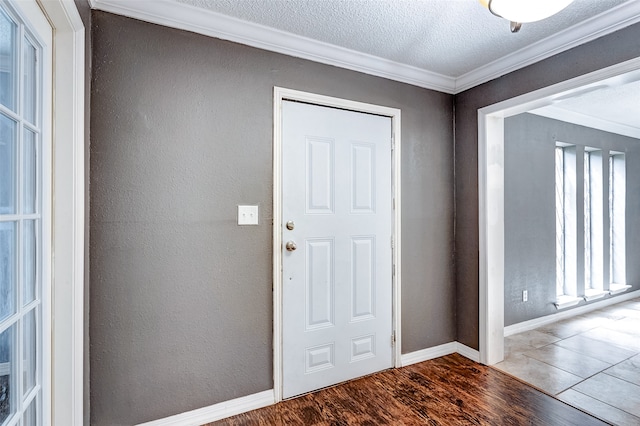 foyer with a textured ceiling, dark wood-type flooring, and ornamental molding