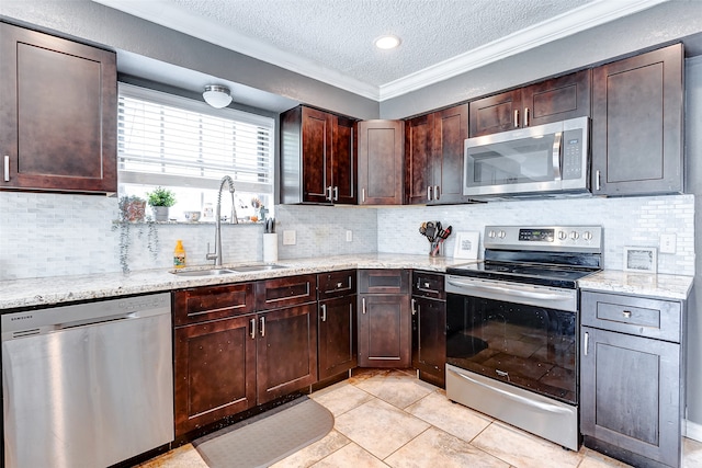 kitchen with backsplash, light tile patterned floors, stainless steel appliances, sink, and a textured ceiling