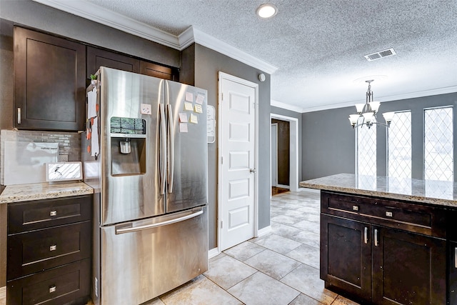 kitchen featuring pendant lighting, ornamental molding, a textured ceiling, stainless steel refrigerator with ice dispenser, and dark brown cabinetry