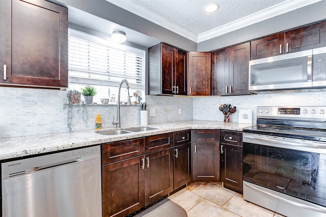 kitchen with stainless steel appliances, sink, light tile patterned flooring, decorative backsplash, and a textured ceiling