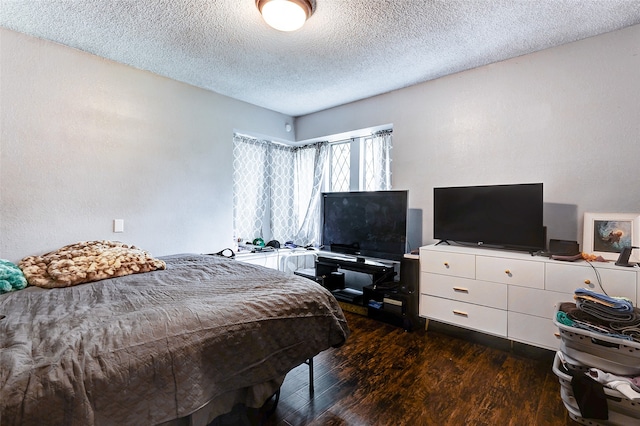 bedroom featuring dark hardwood / wood-style floors and a textured ceiling