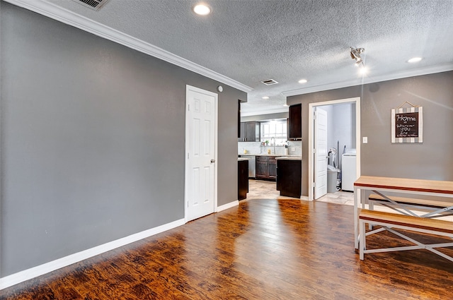 interior space with a textured ceiling, light hardwood / wood-style flooring, and ornamental molding