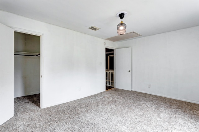 unfurnished bedroom featuring a closet, light colored carpet, and a spacious closet