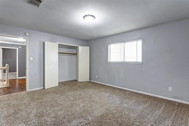 unfurnished bedroom with a textured ceiling and carpet