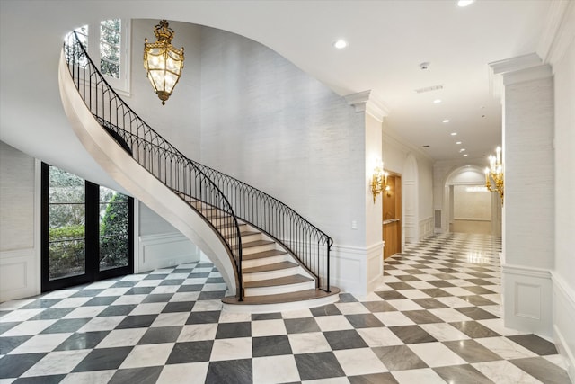 entryway featuring crown molding and an inviting chandelier