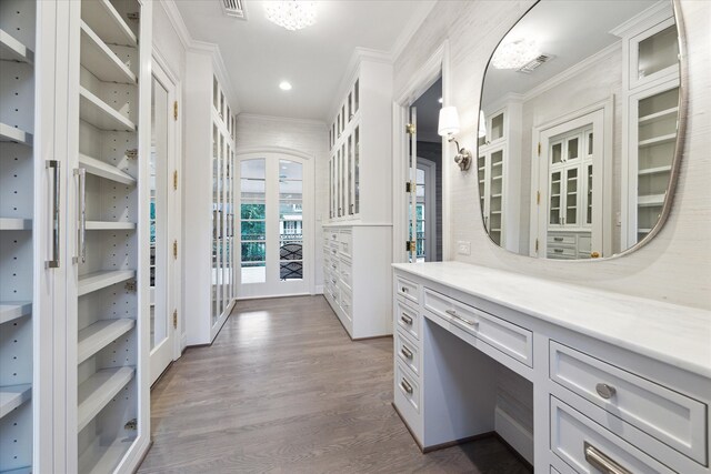 bathroom with french doors, hardwood / wood-style floors, vanity, and ornamental molding