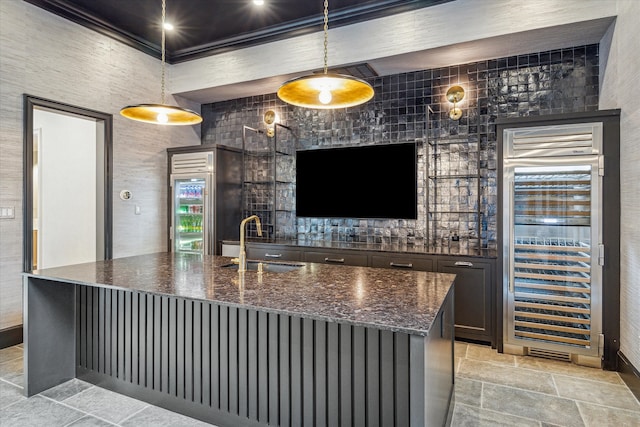 bar featuring dark stone countertops, wine cooler, decorative light fixtures, and sink