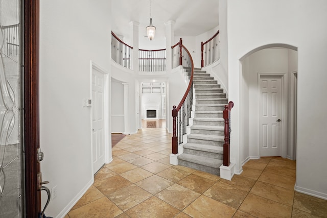 foyer entrance featuring a towering ceiling and a chandelier