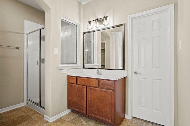 bathroom with vanity and a shower with door