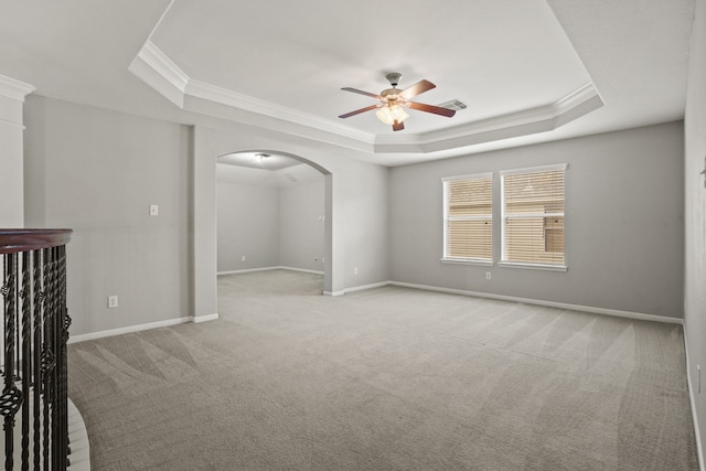 carpeted spare room featuring crown molding, ceiling fan, and a tray ceiling