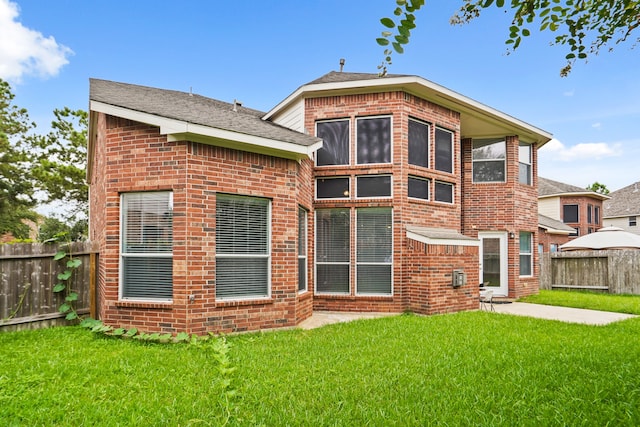 rear view of house with a lawn and a patio