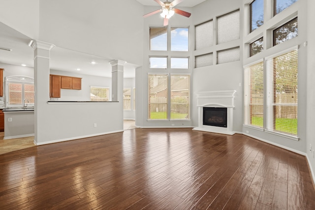 unfurnished living room with ceiling fan, a wealth of natural light, and hardwood / wood-style flooring