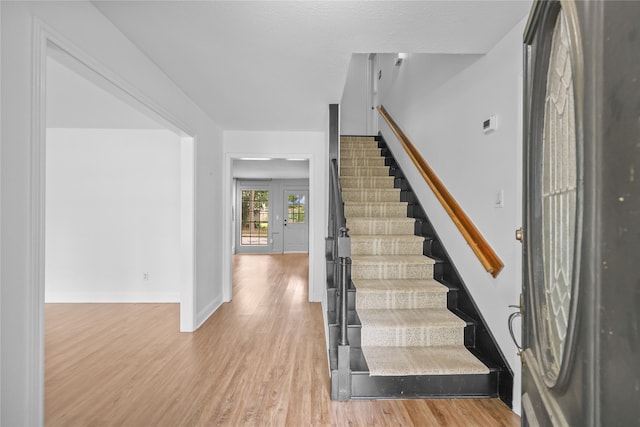 staircase featuring wood-type flooring and french doors