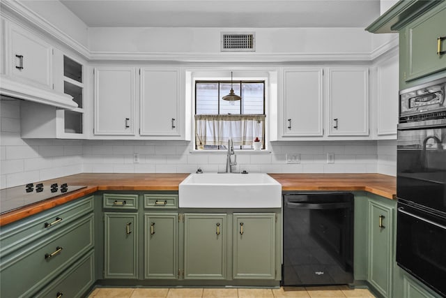 kitchen with black appliances, white cabinetry, butcher block counters, and sink