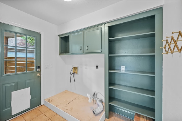 interior space featuring washer hookup, hookup for an electric dryer, cabinets, and light tile patterned flooring