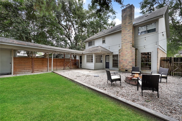 rear view of house featuring a fire pit, a patio area, and a lawn