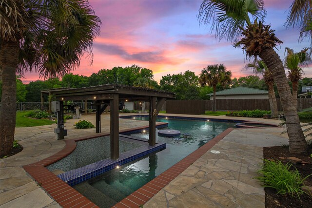 pool at dusk featuring a patio area