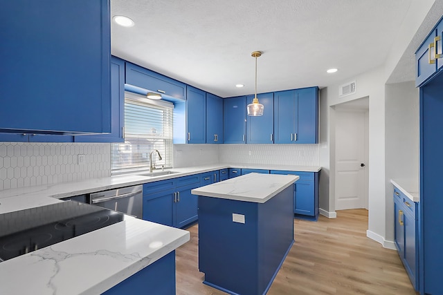 kitchen featuring light stone countertops, pendant lighting, a kitchen island, and sink