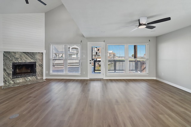 unfurnished living room with lofted ceiling, ceiling fan, wood-type flooring, and a premium fireplace