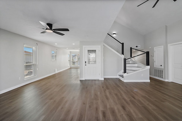 unfurnished living room featuring ceiling fan, dark hardwood / wood-style flooring, and vaulted ceiling