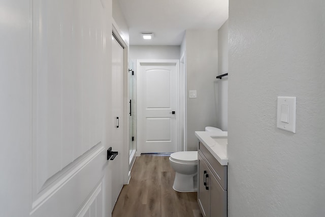 bathroom with hardwood / wood-style floors, vanity, and toilet