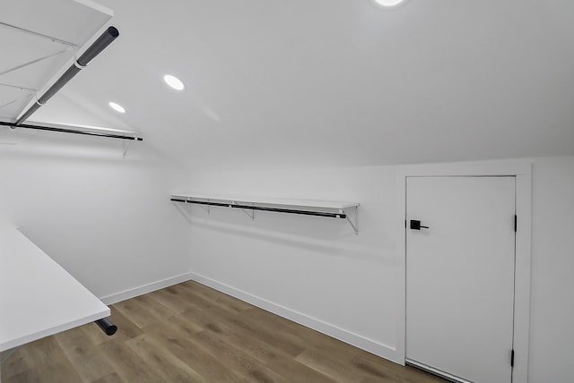 spacious closet with hardwood / wood-style flooring and vaulted ceiling