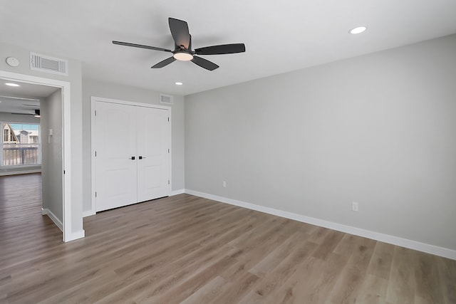 unfurnished bedroom with ceiling fan, a closet, and hardwood / wood-style flooring