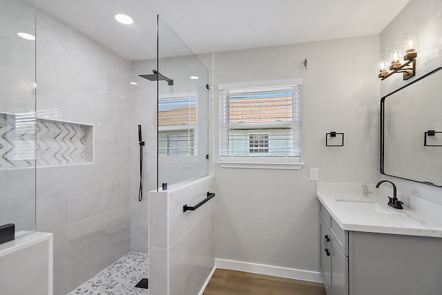 bathroom with a tile shower, vanity, a chandelier, and hardwood / wood-style flooring