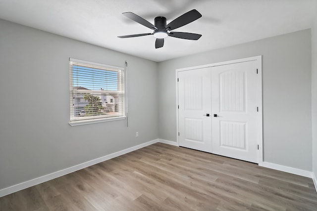 unfurnished bedroom featuring ceiling fan, light wood-type flooring, and a closet